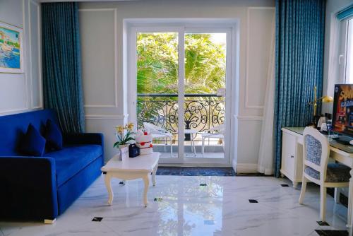 a living room with a blue couch and a window at Lan Rung Beach Resort in Long Hai