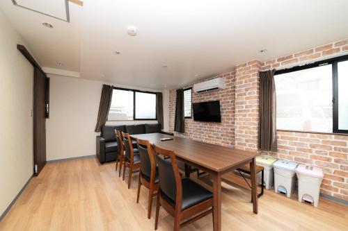 a dining room with a brick wall and a table and chairs at Shinjuku NY House 2 in Tokyo