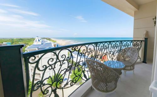 a balcony with chairs and a view of the ocean at Lan Rung Beach Resort in Long Hai