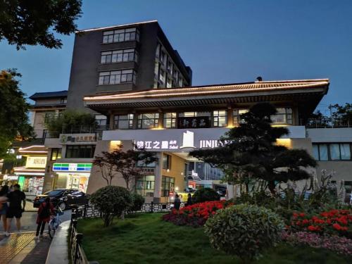 a building on a street with people walking on the sidewalk at Jinjiang Inn Xi'an Zhonglou North Street Metro Station in Xi'an