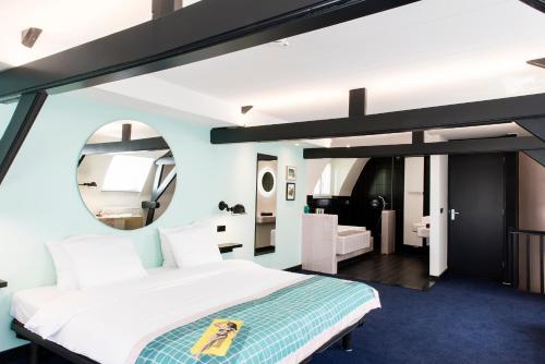 a bedroom with a large bed and a mirror at The Dutch Maastricht in Maastricht