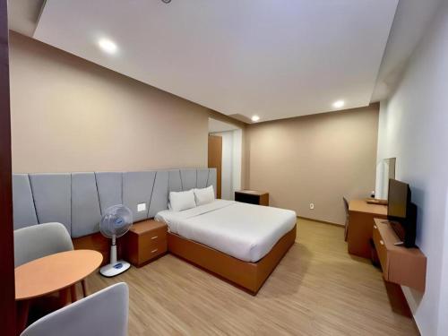 a bedroom with a bed and a desk and a table at Gold View Boutique Hotel Đà Lạt in Da Lat