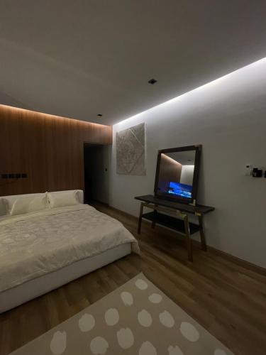 a bedroom with a bed and a television on a table at Aurum studio in Riyadh