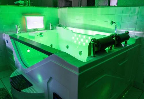 a green bathroom with a tub with a computer monitor at Super 8 by Wyndham Uniontown PA in Uniontown