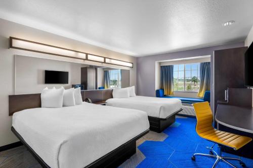a hotel room with two beds and a television at Microtel Inn & Suites By Wyndham Conway in Conway