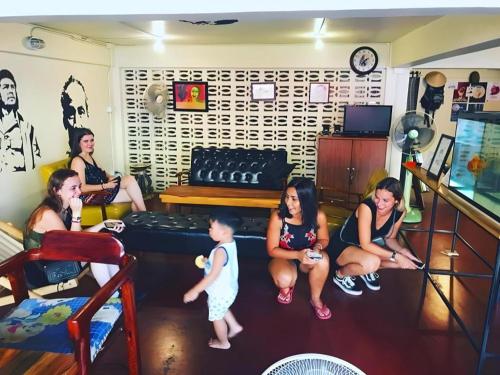 a group of women and a child in a living room at Oldie and Sleepy Hostel in Udon Thani