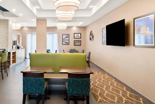 a dining room with a table and a television at Comfort Suites New Orleans East in New Orleans