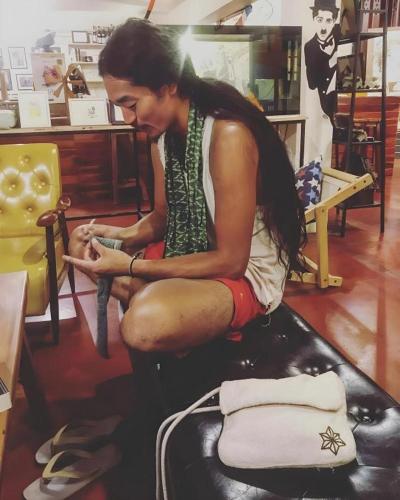 a woman sitting on a chair in a store at Oldie and Sleepy Hostel in Udon Thani