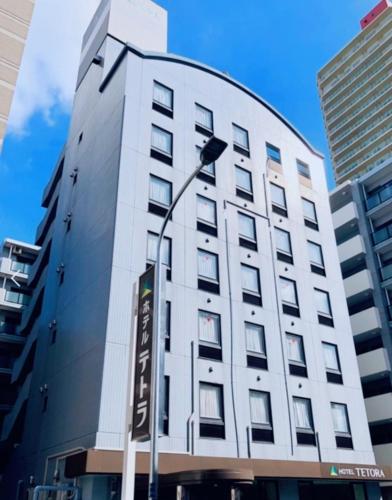 a tall building with a street light in front of it at Hotel Tetora Makuhari Inagekaigan (Formerly Business Hotel Marine) in Chiba