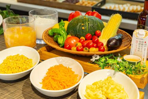 a table topped with bowls of different types of vegetables at Hotel Keihan Kyoto Hachijoguchi in Kyoto