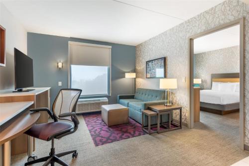 a hotel room with a bed and a desk at Home2 Suites by Hilton Atlanta Airport North in Atlanta