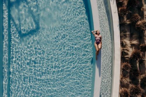 an overhead view of a woman in a swimming pool at Niléa Island Living in Agia Anna Naxos