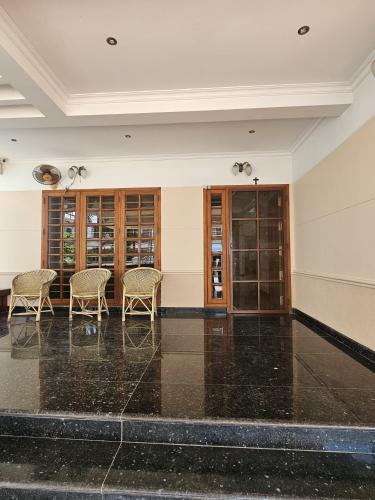 an empty room with chairs and glass doors at Vipanchika Home Stay in Trivandrum