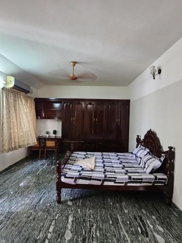 a bedroom with a bed with a wooden headboard at Vipanchika Home Stay in Trivandrum