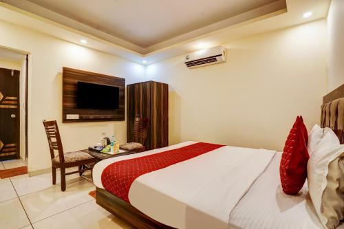 a bedroom with a bed and a desk and a television at Hotel New City Lite Near Delhi in New Delhi