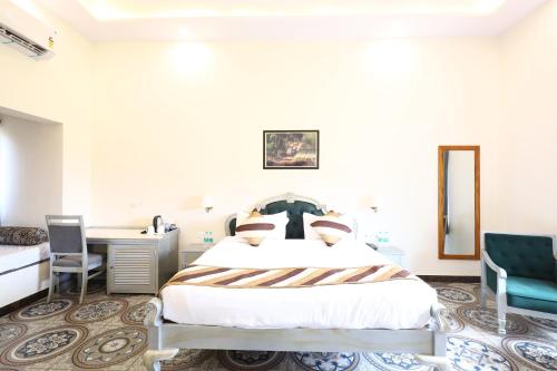 a bedroom with a bed and a desk and chairs at Sajjan Jawai Chapter by Arow Hospitality in Mori Bera