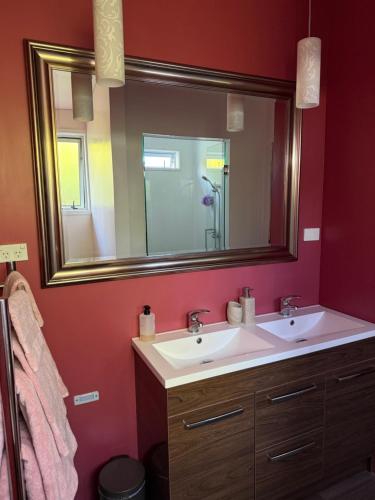 a bathroom with two sinks and a large mirror at Bed and Breakfast Happy Home Taupo Accommodation in Taupo