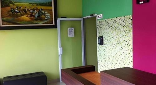 a room with green and pink walls and a mirror at Pineapple Mansion in Solo