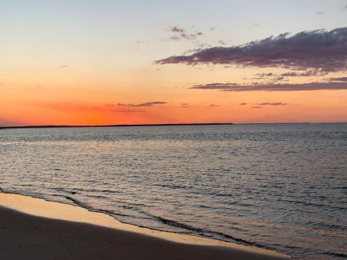 a sunset over the ocean with a sandy beach at 'Jemingar's Place' 207 - Rainbow Beach in Rainbow Beach