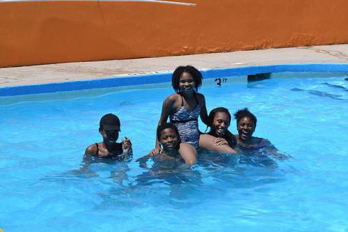 a woman standing in a swimming pool with a group of children at Americas Best Value Inn Smithfield in Smithfield