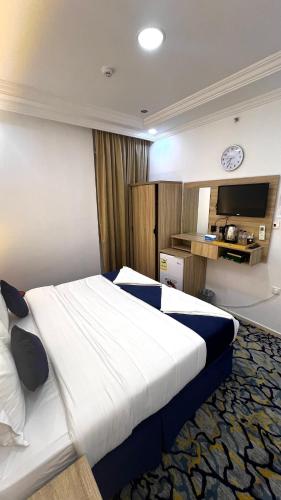 a hotel room with a large bed and a tv at فندق شركة صلاح المدينة in Az Zāhir
