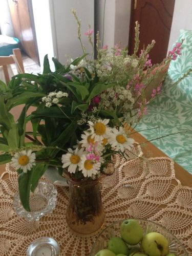 a vase with flowers in it on a table at Eco Garten Guest House in Shkodër
