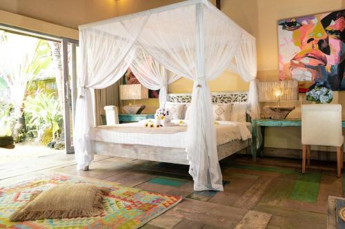a bedroom with a bed with a canopy at Villa Fleur in Tumbak Bayuh