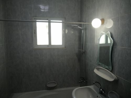 a bathroom with a sink and a tub and a window at ميرا للشقق المفروشة Mera Apartment in Aqaba
