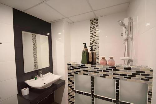 ein Badezimmer mit Waschbecken und Spiegel in der Unterkunft P1 House in Sathani Phitsanulok