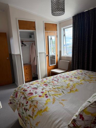 a bedroom with a bed and a chair and a window at Bed and Breakfast Happy Home Taupo Accommodation in Taupo