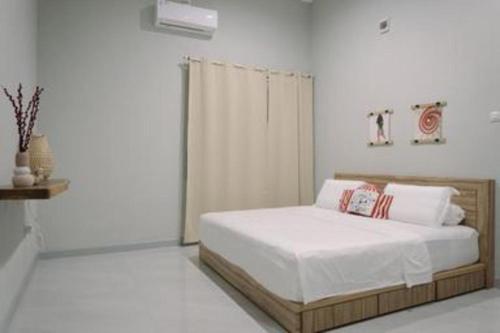 a bedroom with a bed in a white room at Kenari Tower Hotel in Makassar