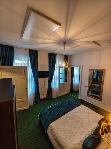 a bedroom with a large bed and a mirror at Margarets Place in Braşov