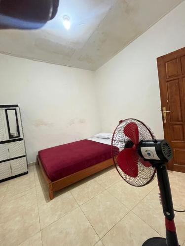 a room with a bed with a fan in it at Ijen Transito 2 homestay in Ketapang