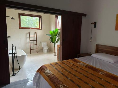 une chambre avec un lit, une baignoire et une fenêtre dans l'établissement Villa Vindo - 1BR & Swimming pool, à Kuta Lombok