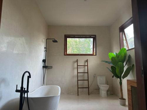 une salle de bain avec baignoire et toilettes et une fenêtre dans l'établissement Villa Vindo - 1BR & Swimming pool, à Kuta Lombok