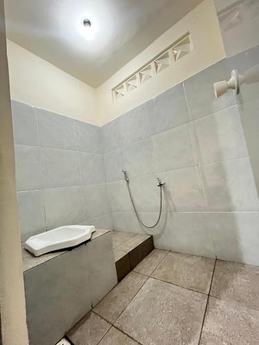 a bathroom with a shower with a toilet in it at Ijen Transito 2 homestay in Ketapang