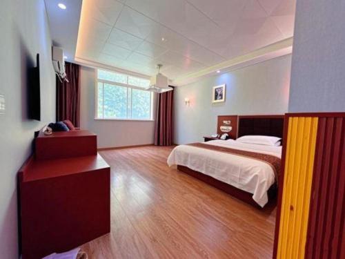 a large bedroom with a bed and a wooden floor at Super 8 Hotel Shiyan Beijing Middle Road in Shiyan