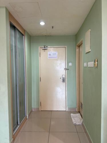 un couloir avec une porte dans une chambre aux murs verts dans l'établissement The Viana Apartment V, à Kota Bharu