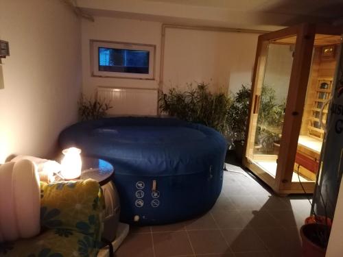 a living room with a large blue ottoman and a table at Staff Guest House in Nyíregyháza