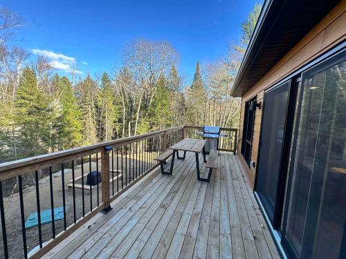 a wooden deck with a picnic bench on it at Foosball table Spa & Sauna - Sommetoile in Saint Come