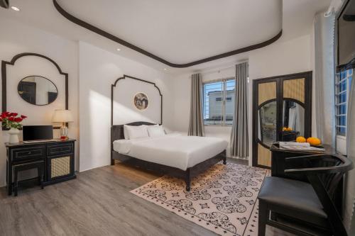 a bedroom with a white bed and a mirror at Golden Glow Hue City in Hue