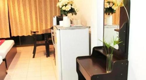 a room with a refrigerator with flowers on top of it at Rim Kaeng resort in Phetchaburi