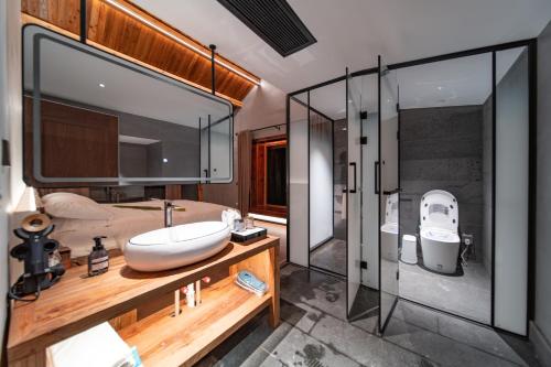 a bathroom with a sink and a toilet and a shower at 雾里观阵山 Foggy Valley in Zhangjiajie