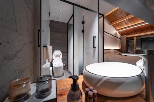 a bathroom with a large white bath tub on a table at 雾里观阵山 Foggy Valley in Zhangjiajie