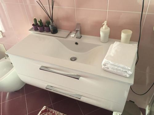 ein Badezimmer mit einem weißen Waschbecken und einem WC in der Unterkunft Supera Napoli Apartment in Neapel