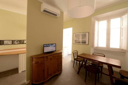 een woonkamer met een eettafel en een televisie bij Via Montebello in Rome