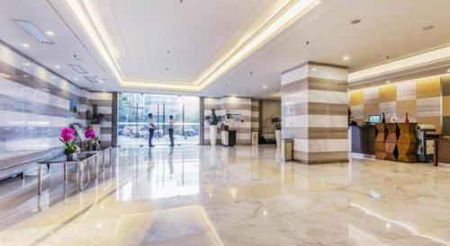 a lobby of a building with a person walking in it at The Bauhinia in Shenzhen