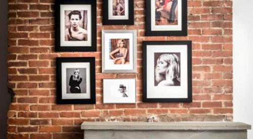 a wall of pictures on a brick wall at The George Montclair in Montclair