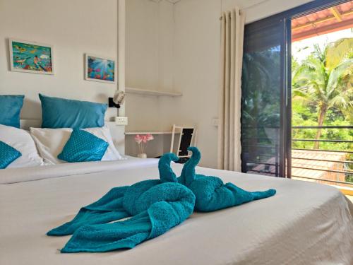due animali di peluche sono sdraiati su un letto di Blue Clouds l Palolem-Agonda ad Agonda