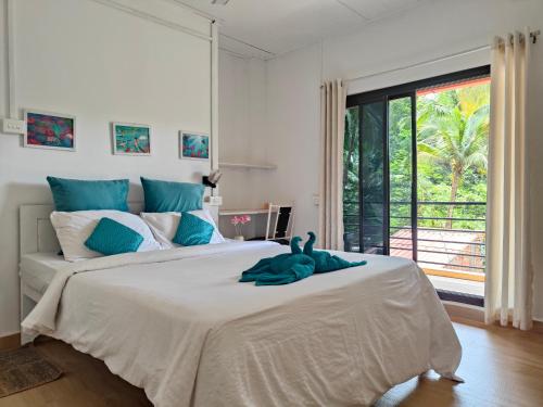una camera da letto con un grande letto e un animale di peluche di Blue Clouds l Palolem-Agonda ad Agonda
